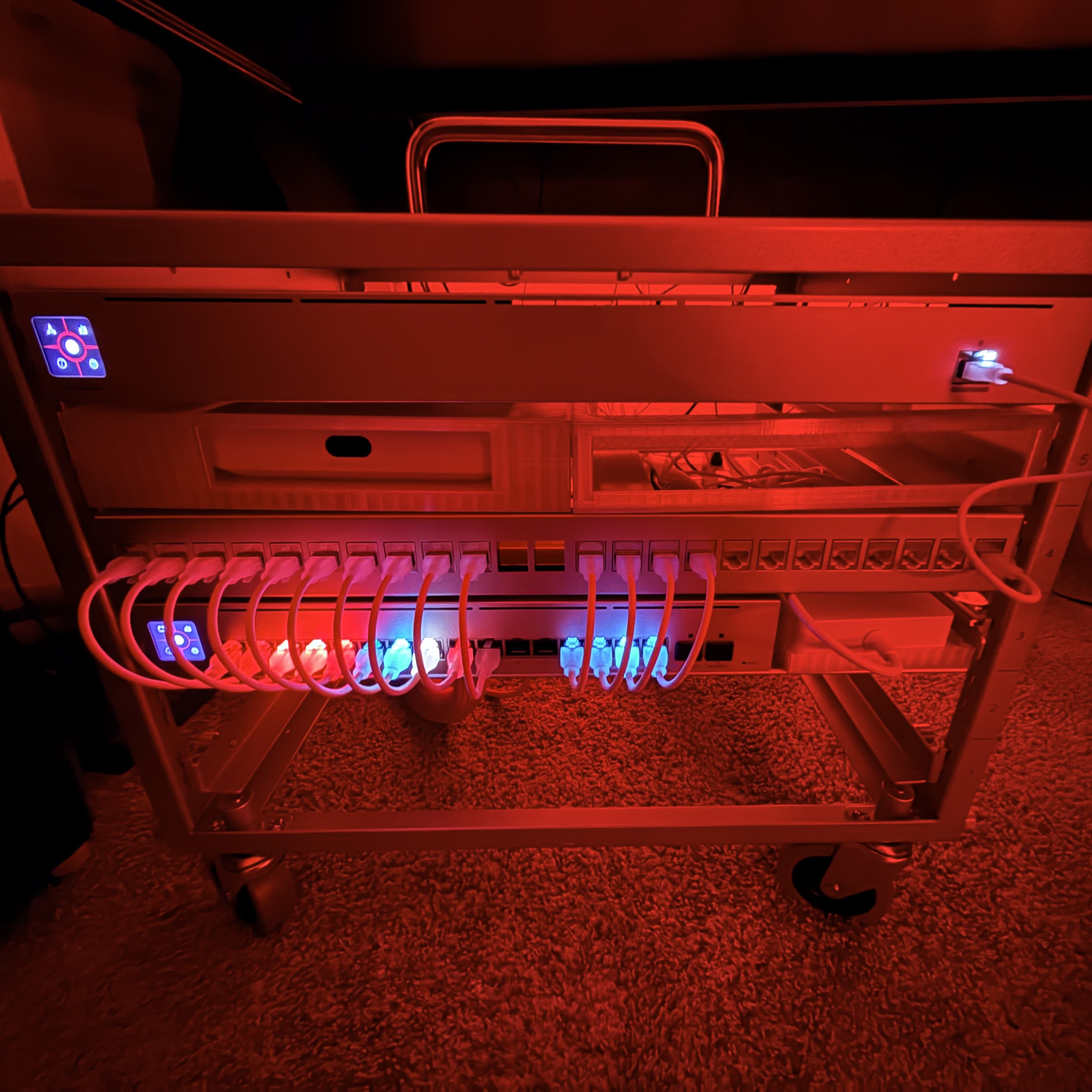 Ubiquiti UniFi network rack with managed switches, patch panel, gateway, and connected Ethernet cabling